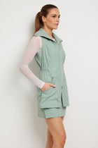The Best Travel Vest. Woman Showing the Side Profile of an Embossed Delaney Vest in Cheetah Sage.