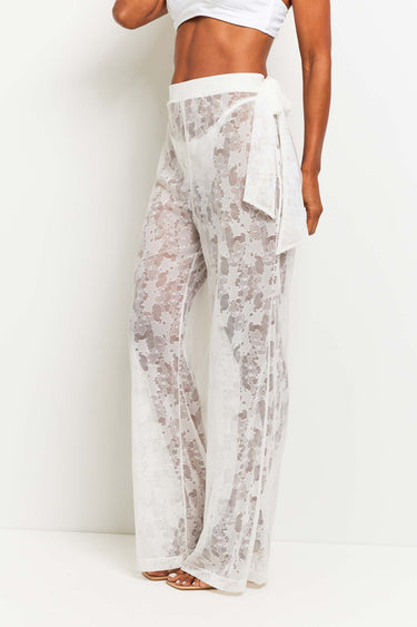 The Best Travel Pants. Woman Showing the Side Profile of a Moana Camo Mesh Pant in White.